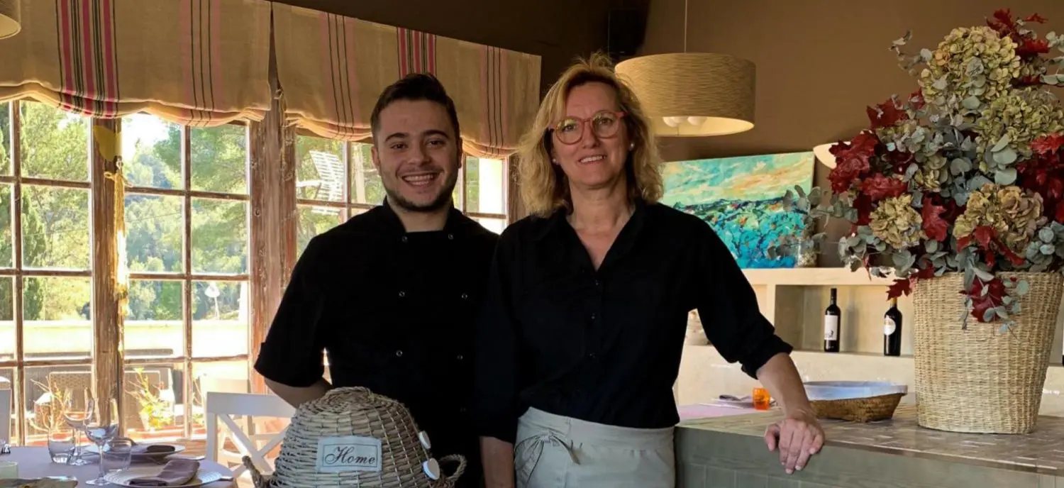 Dos cocineros preparando platos en el restaurante Cal Agustí de la masía rural en el Penedès